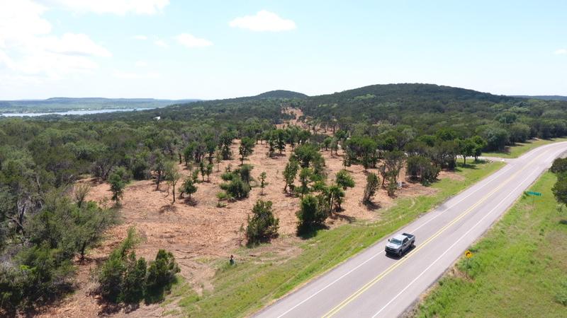 The same tract from the air after clearing, with cedar and brush removed, mature oaks left standing and the ground raked clean